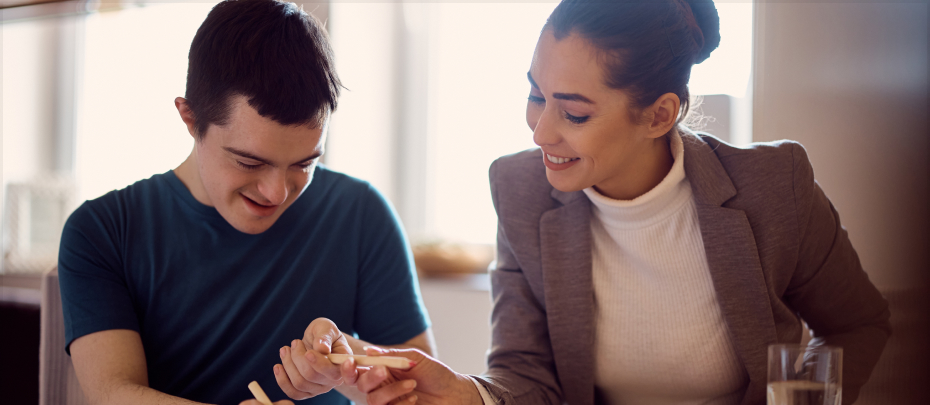 A man and woman sit at a table, reviewing a piece of paper together, engaged in discussion.