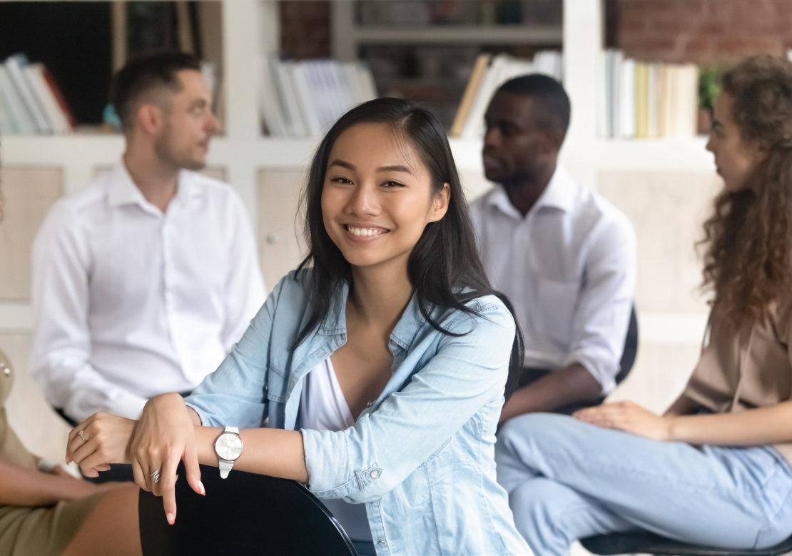 A diverse group of young people engaged in conversation while sitting in a circle, fostering connection and collaboration.