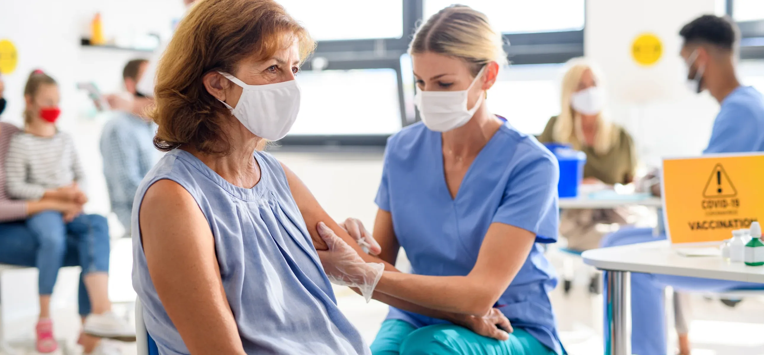 A nurse administers a vaccination to a patient in a clinical setting, ensuring proper care and attention.