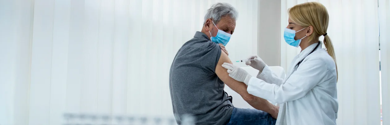 A doctor administers a vaccine to a patient in a clinical setting, ensuring proper care and safety during the procedure.